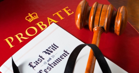 Probate folder with a last will and testament in the foreground, a judge's gavel on top of both